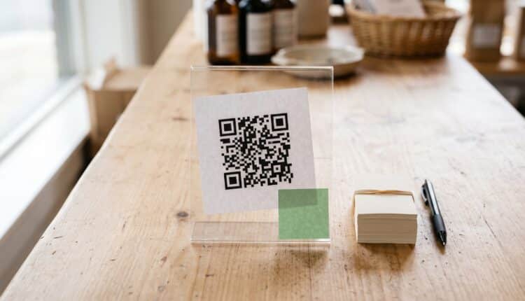 QR code impresso em display de balcão de loja usado para divulgar um canal do WhatsApp
